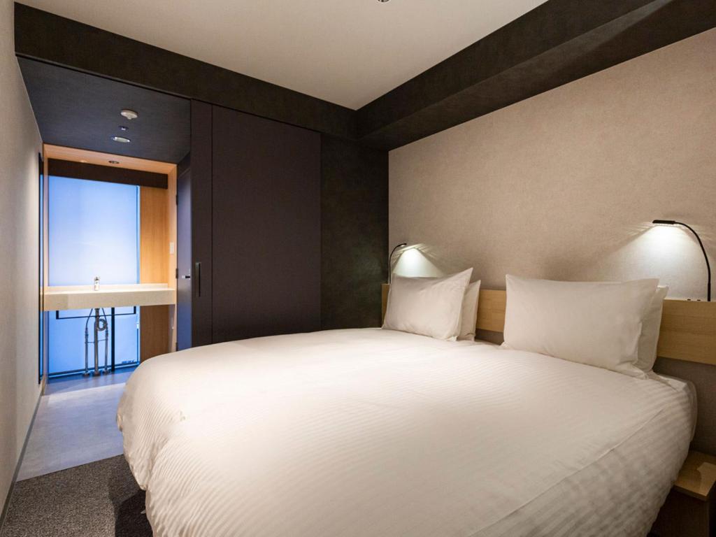 Postel nebo postele na pokoji v ubytování Akabane Holic Hotel