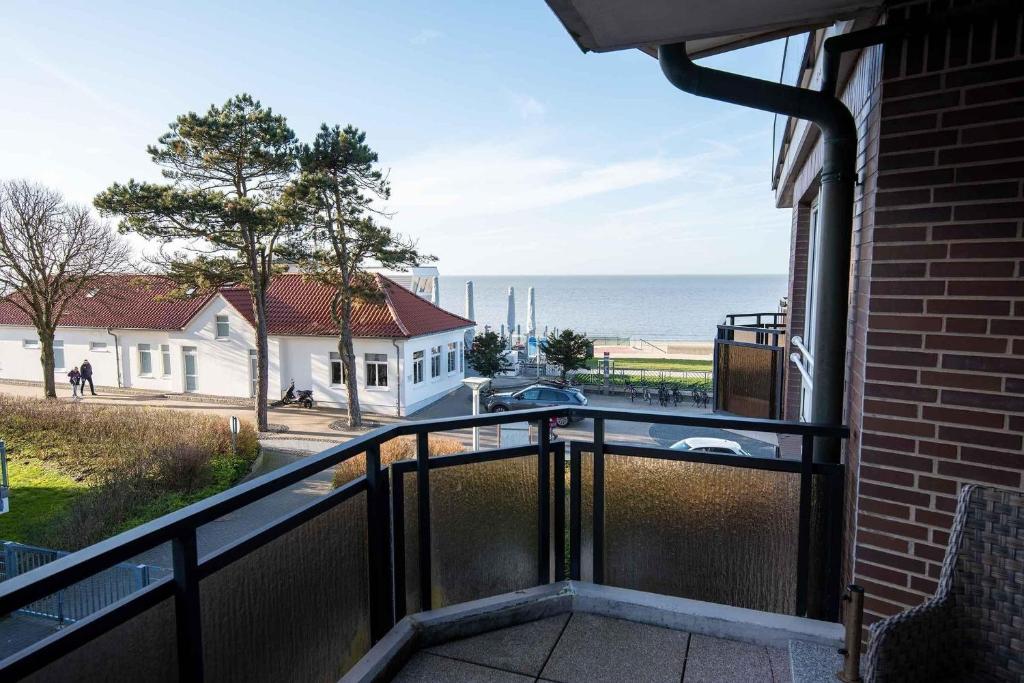 een balkon met uitzicht op de oceaan vanuit een huis bij Meerblick-Ferienwohnung-30-in-der-Residenz-Meeresbrandung in Cuxhaven