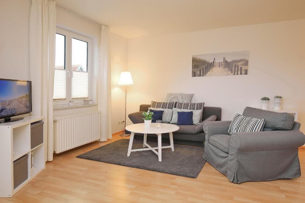 uma sala de estar com um sofá e uma mesa em Waterkant Wohnung 04 -Promenadendeck em Boltenhagen