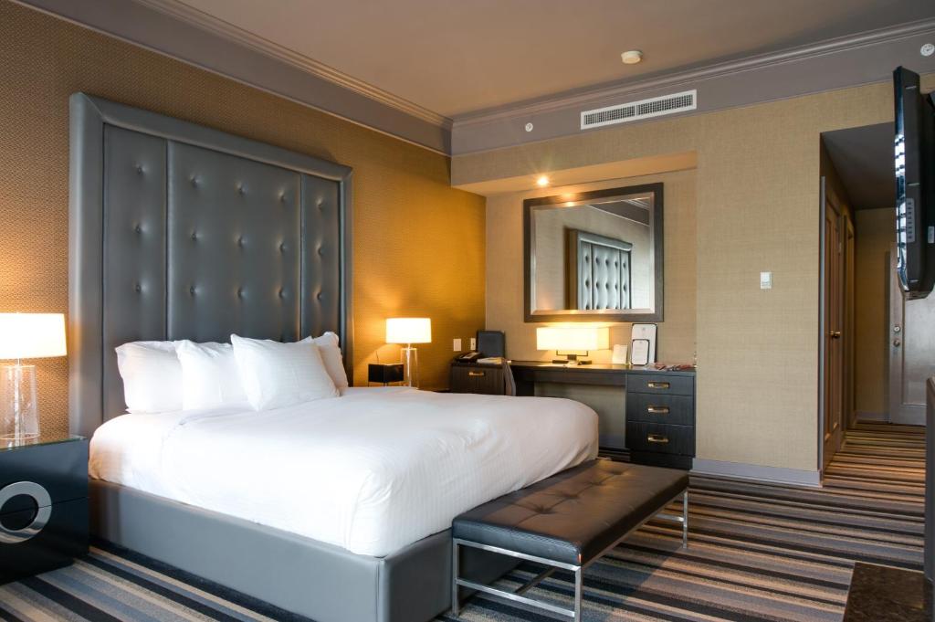 a bedroom with a large white bed and a desk at Hotel Arts Kensington in Calgary