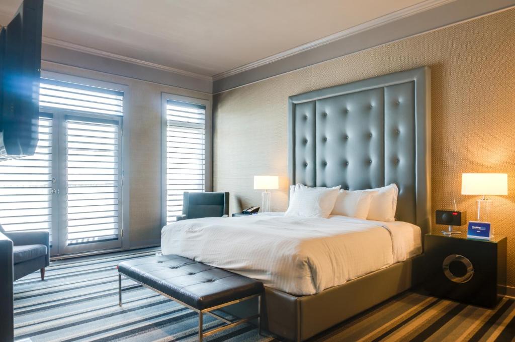 a bedroom with a large bed and a chair at Hotel Arts Kensington in Calgary