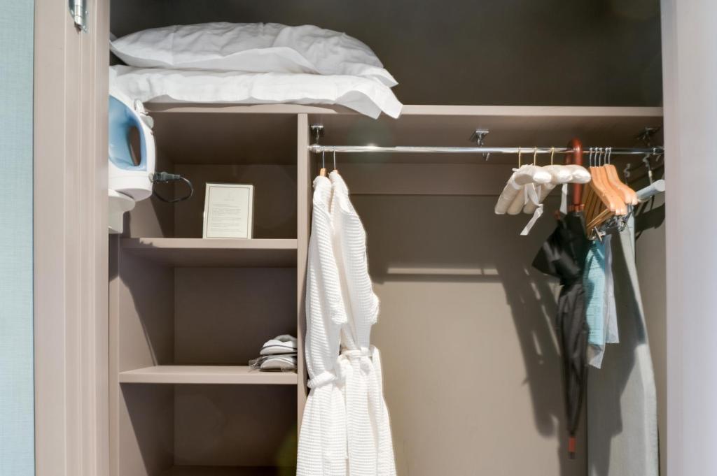 a walk in closet with a bed and towels at Hotel Arts Kensington in Calgary