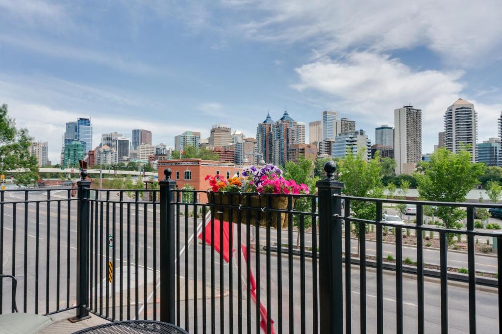 a black fence with flowers and a city skyline at Hotel Arts Kensington in Calgary