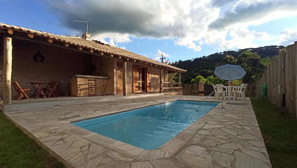 ein Haus mit einem Pool vor einem Haus in der Unterkunft AIR Casa do Lago BNB OFF in Águas da Prata
