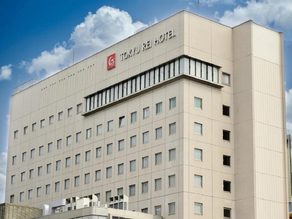 un edificio blanco con un cartel en la parte superior en Nagano Tokyu REI Hotel, en Nagano