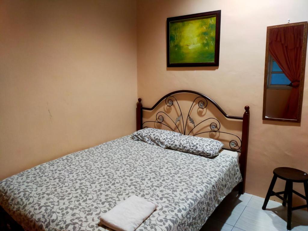 a bedroom with a bed and a picture on the wall at Homestay Sri Uda A in Alor Setar