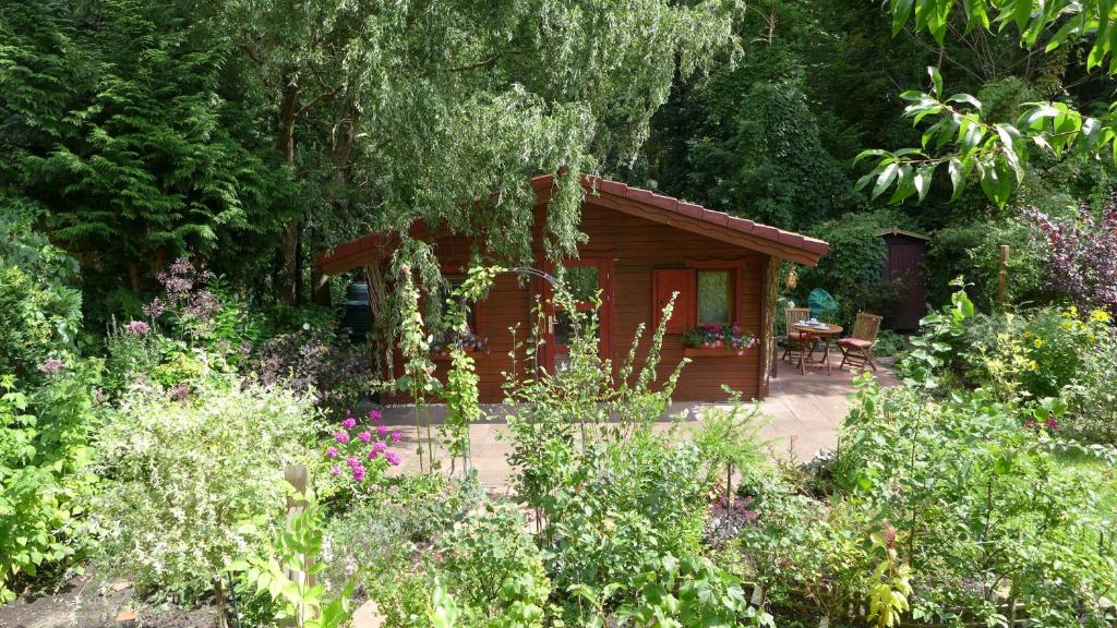 a small cabin in the middle of a garden at Ferienhaus Natura in Neuruppin