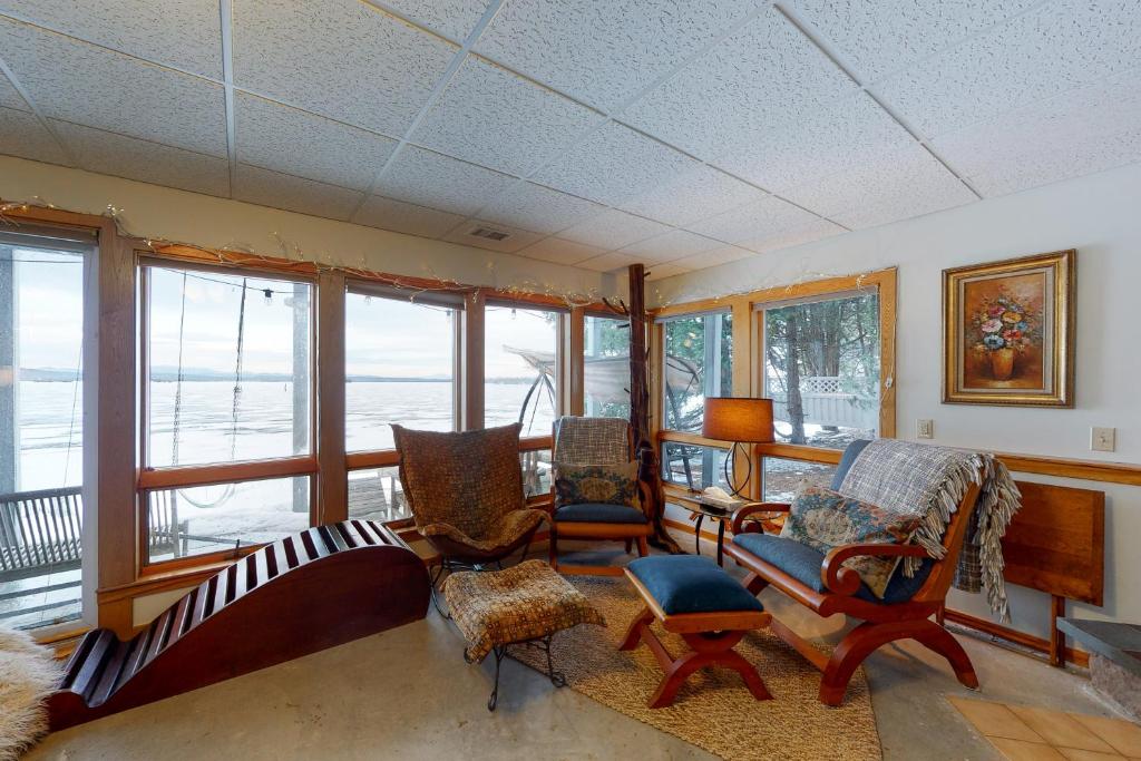 een woonkamer met stoelen, een bank en ramen bij Isle Be Back in Grand Isle