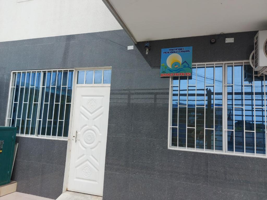porta bianca in un edificio con finestre di Habitacion Vacacional Camboriu a Salinas
