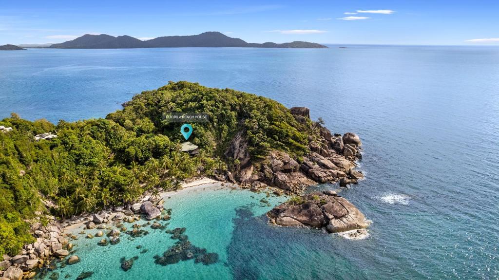 an island in the ocean with a house on it at Doorila Beach House in Bedarra Island