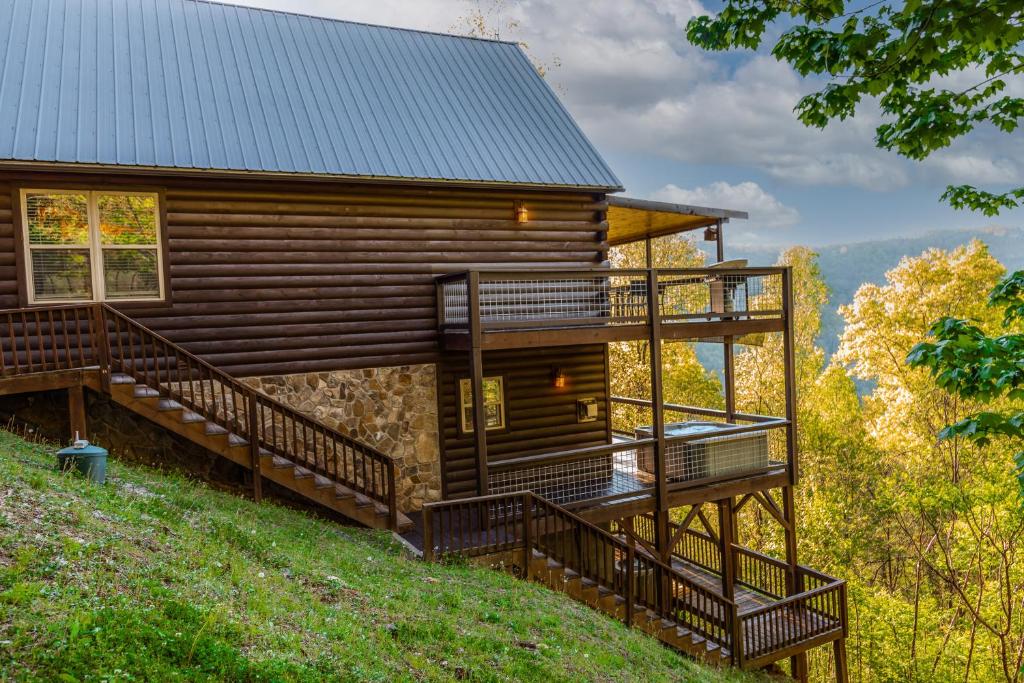 a log cabin with a deck and stairs at Sun Eagle Lodge in Bryson City