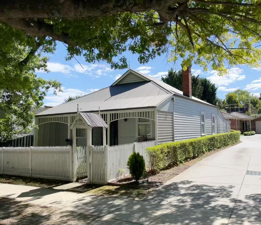 a house with a white fence in front of it at Magnolia Cottage in Healesville