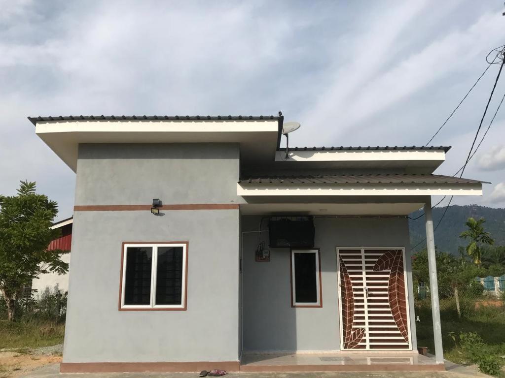 una pequeña casa blanca con techo en Teratak Ar-Rayyan x Villa Abi, en Batu Kurau