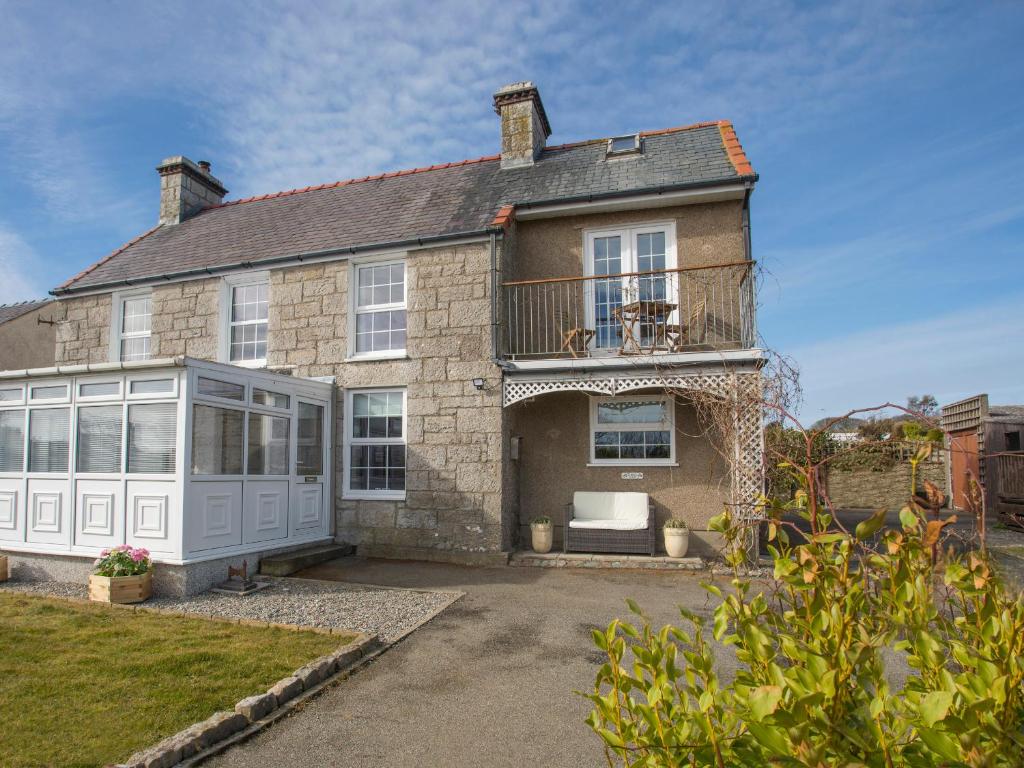 a large brick house with a balcony at Seiriol View in Moelfre