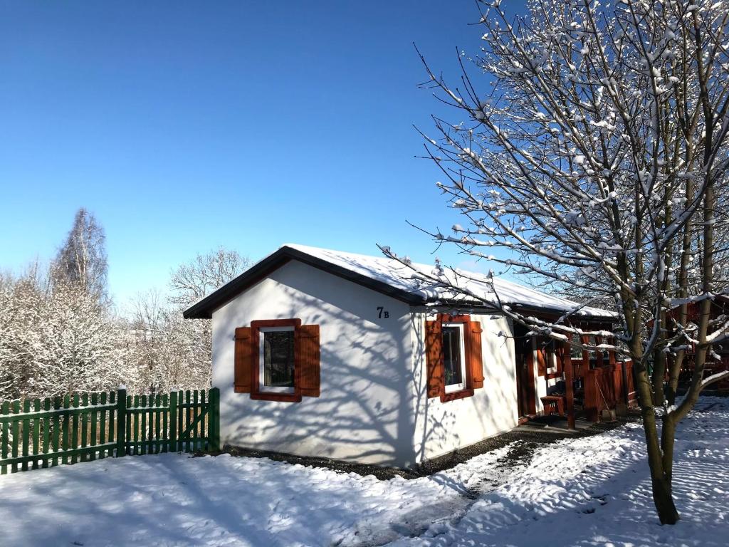 een wit huis in de sneeuw met een hek bij Domek w górach na wyłączność Karkonosze in Mniszków