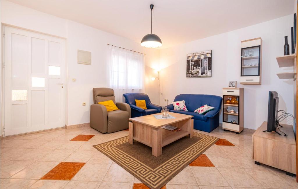 salon z 2 niebieskimi kanapami i telewizorem w obiekcie Amazing Apartment In Krusevo w mieście Kruševo