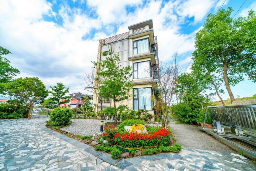 an apartment building with a flower garden in front of it at My Sweetie B&B in Dongshan