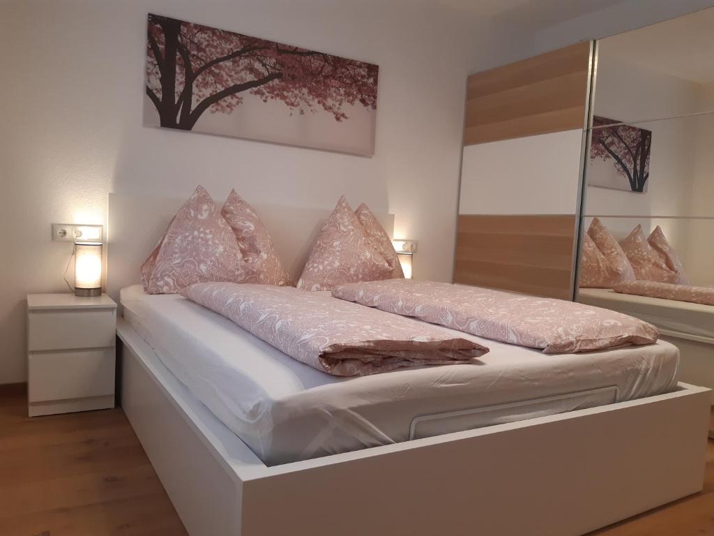 a white bed with pillows on it in a room at Ferienwohnung - Gwiggner Daniela in Niederau