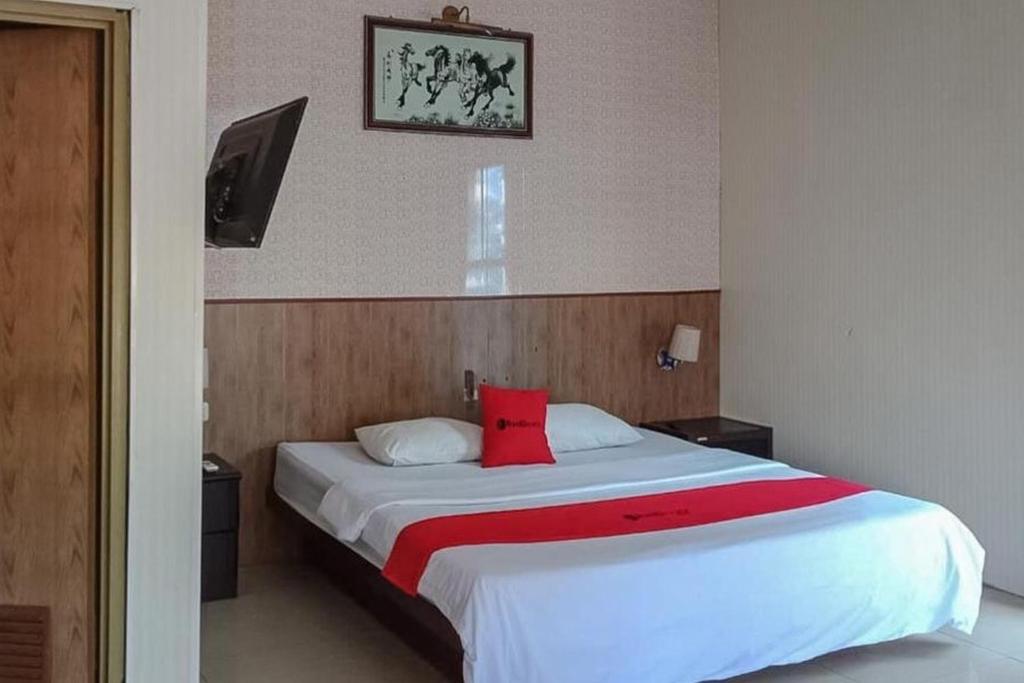 - une chambre avec un grand lit et un oreiller rouge dans l'établissement RedDoorz @ Sorong City Center, à Sorong