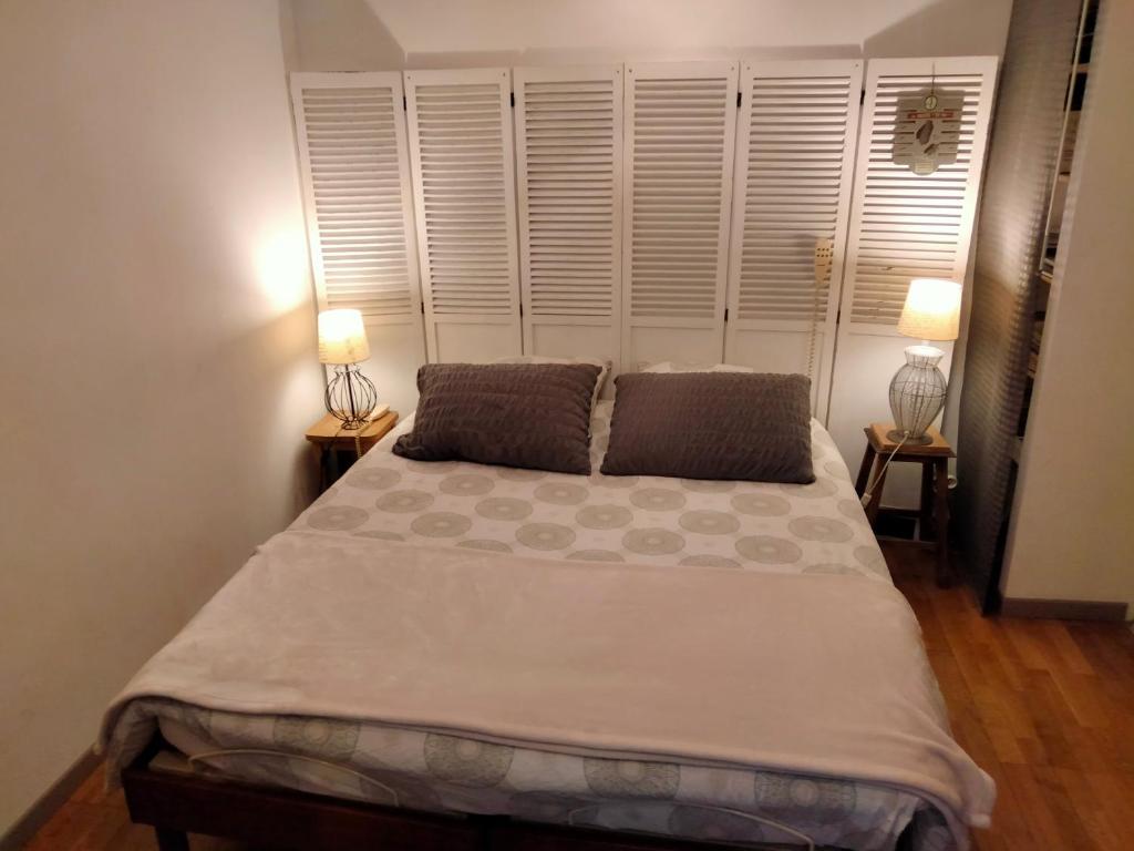 a bedroom with a large bed with two lamps on tables at Appartement T2 sur cour nantaise in Rezé
