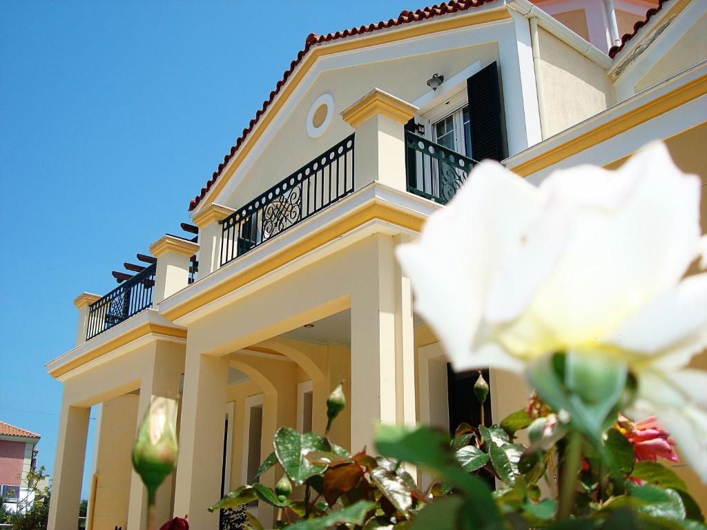 een groot wit huis met een balkon bij Remenata in Lixouri