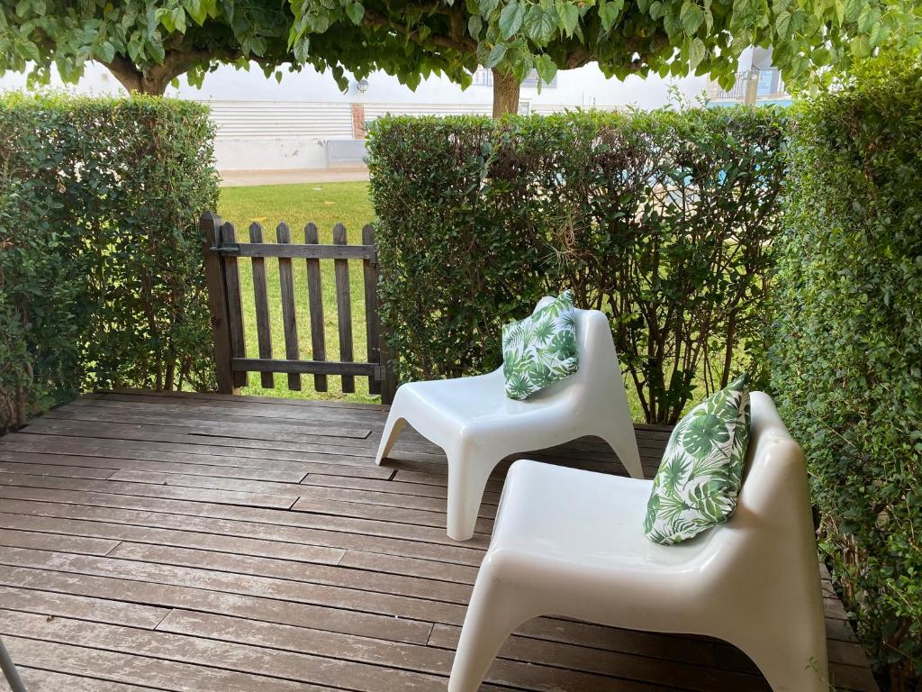 聖卡洛斯拉臘皮塔的住宿－Arcs15，木制庭院里设有两把白色椅子