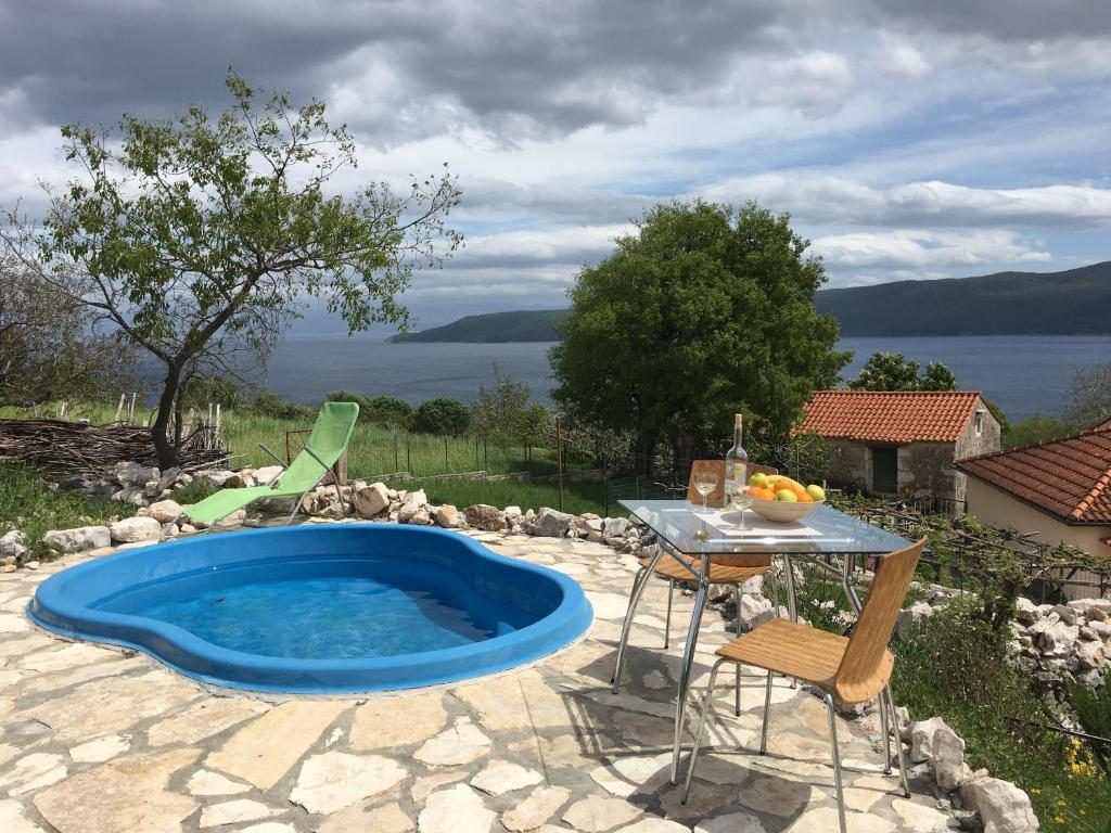 uma piscina no meio de um pátio com uma mesa em Brestova Sun em Zagorje