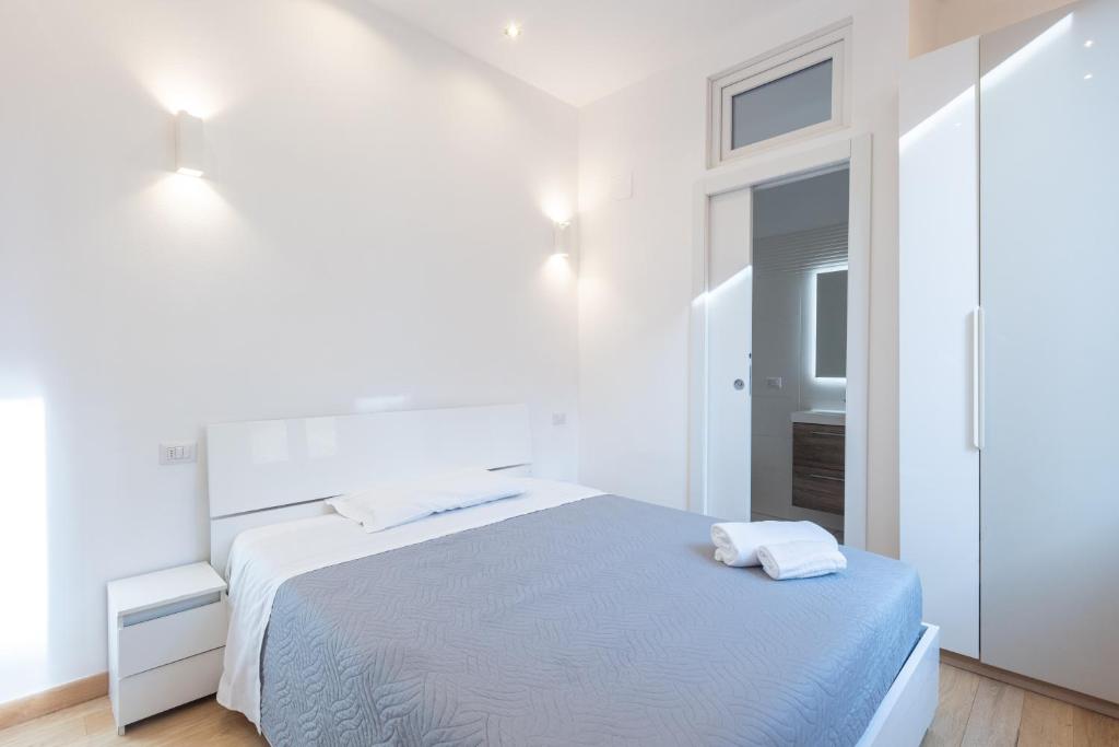 a white bedroom with a bed and a mirror at Garisenda, Bologna by Short Holidays in Bologna