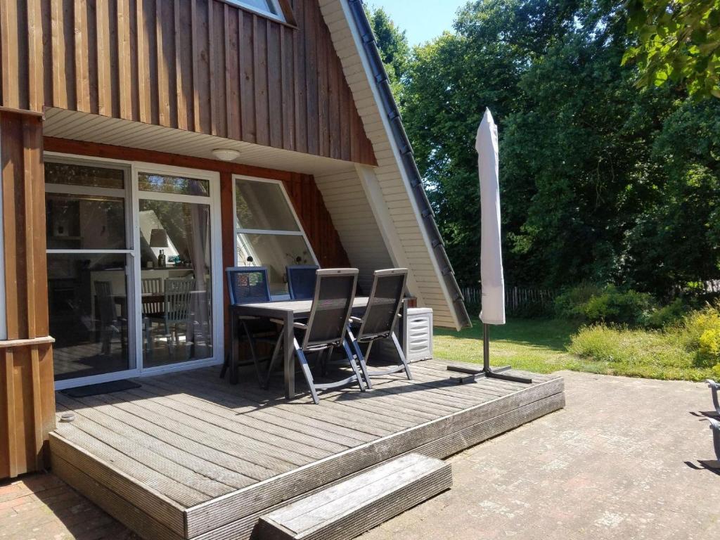eine Holzterrasse mit einem Tisch und Stühlen darauf in der Unterkunft Aalborg in Brodersby