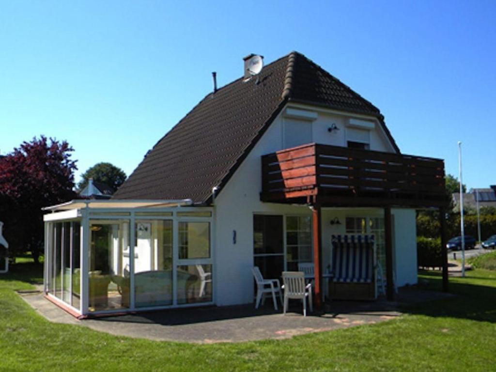 a small house with a conservatory with a roof at Fanö Huset in Boren