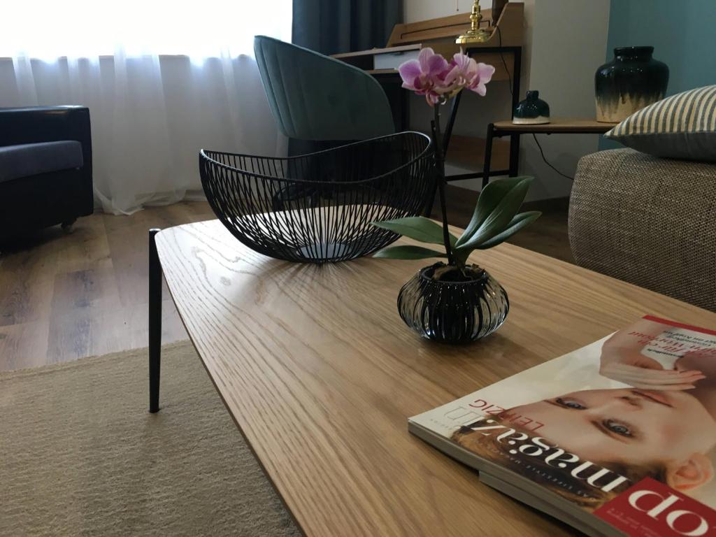 a table with a flower in a vase on it at Attraktive Ferienwohnung am Rande von Leipzig an der A14 in Taucha