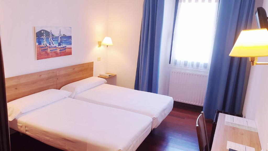 A bed or beds in a room at Hotel Zarauz