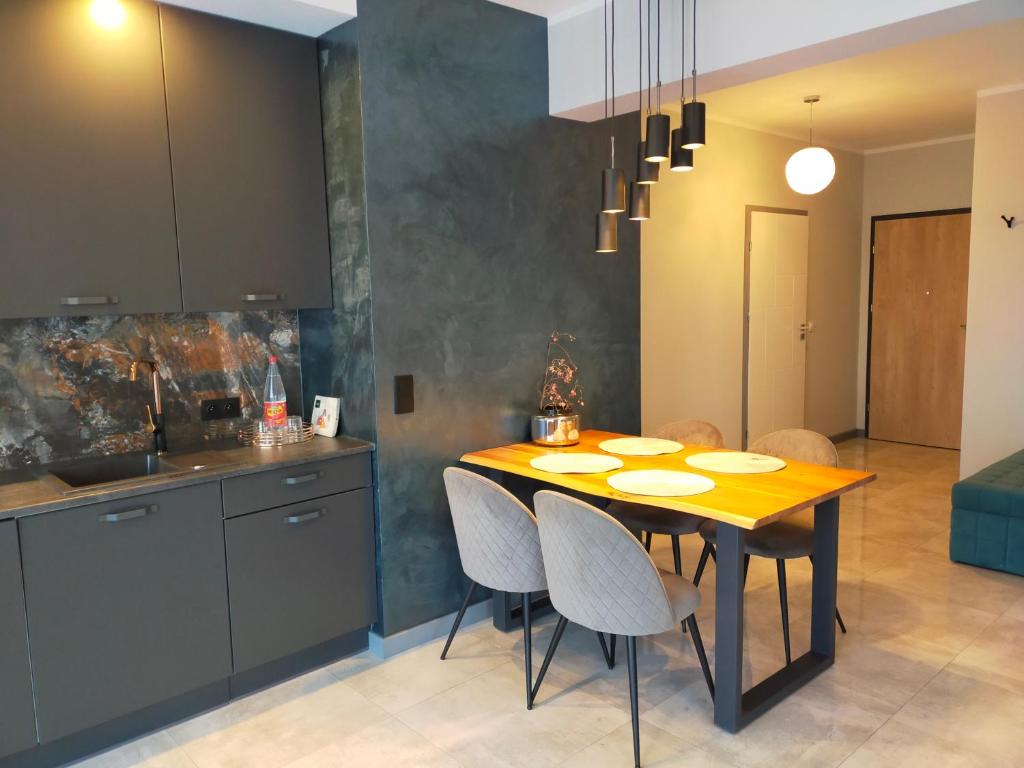Apartament Blue Sky في لوبين: مطبخ مع طاولة وكراسي في غرفة