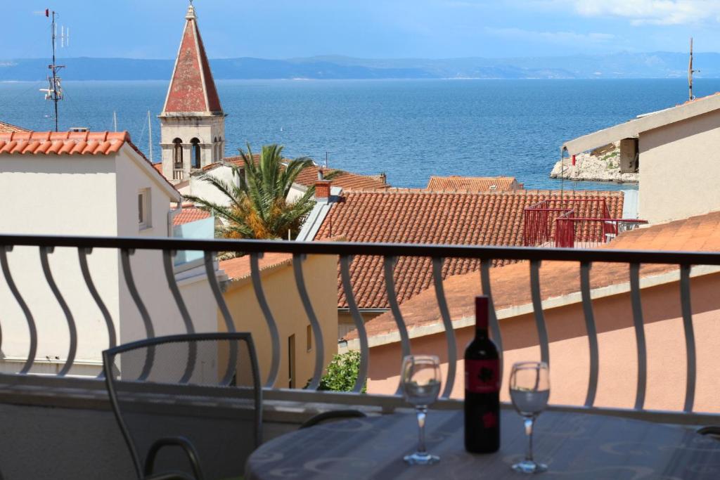 a balcony with a table and two glasses of wine at Villa Flamingo in Makarska