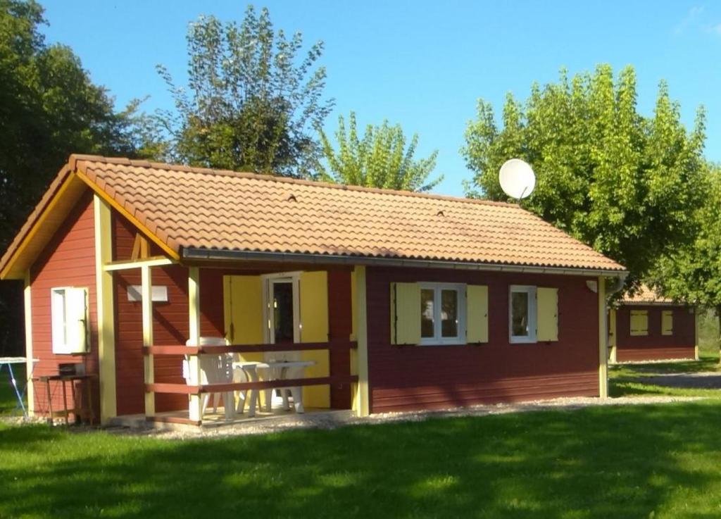 ein kleines rotes und gelbes Haus in einem Hof in der Unterkunft Chalet edelweiss 35 in Mélisey