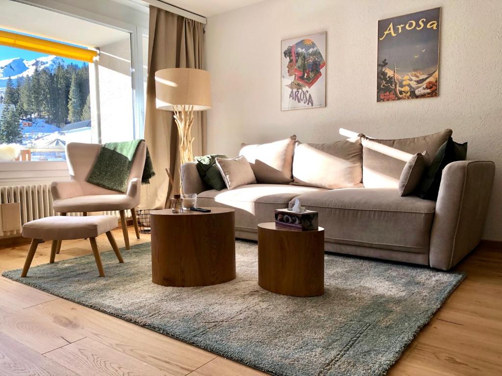 a living room with a couch and two tables at Calarosa Boutique Apartment Arosa in Arosa