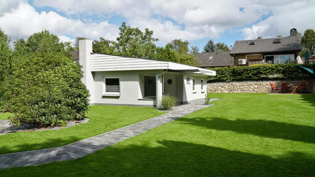 a white house with a green lawn at Die Fünf in Brodersby