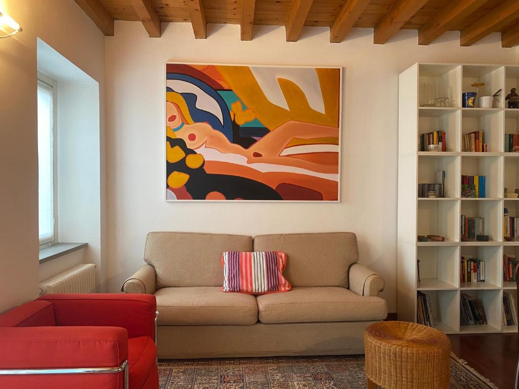 a living room with a couch and a painting at CASA HERMES in Bergamo
