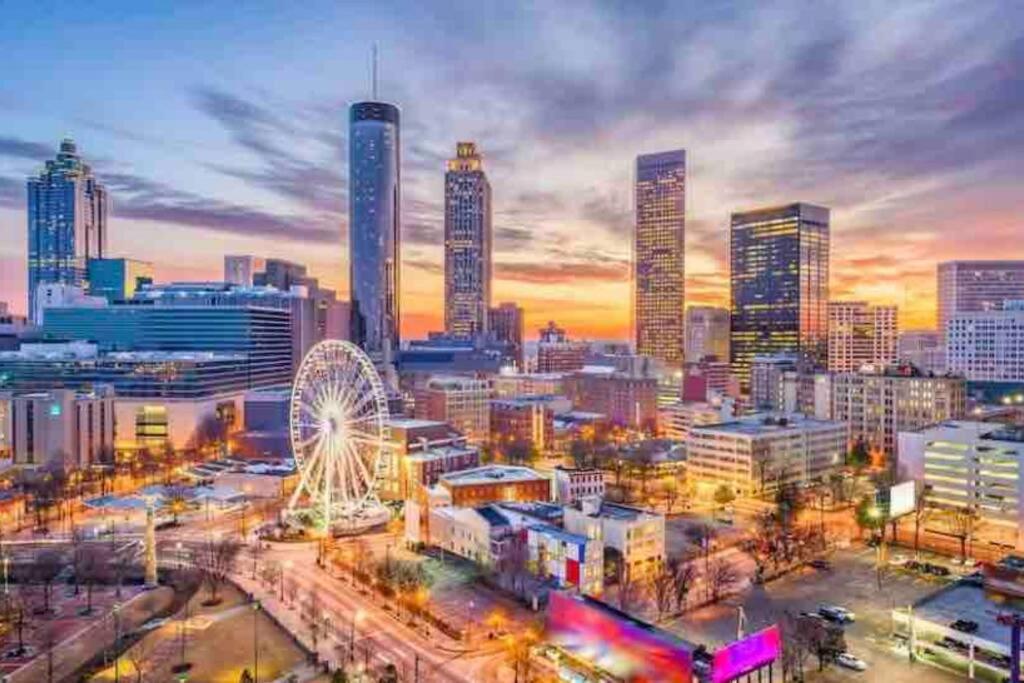 a city skyline at sunset with a ferris wheel at BMW Suite King Bd,WD, Fast WiFi Free Parking, Pool, Hospitals in Atlanta