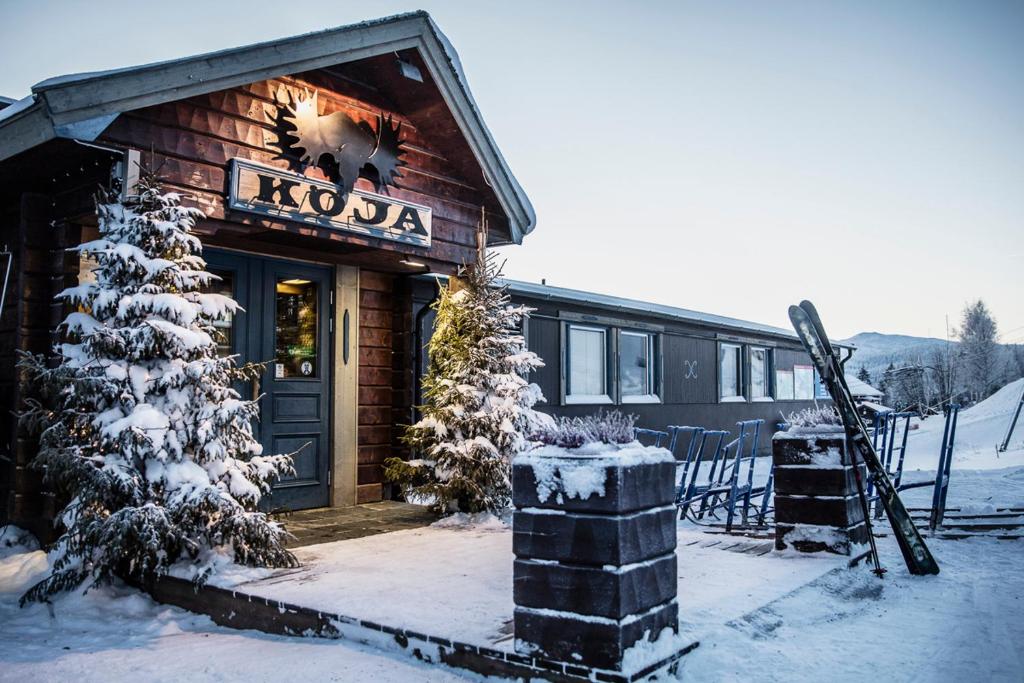 a building with a koala sign on it in the snow at Köja Fjällhotell in Edsåsdalen