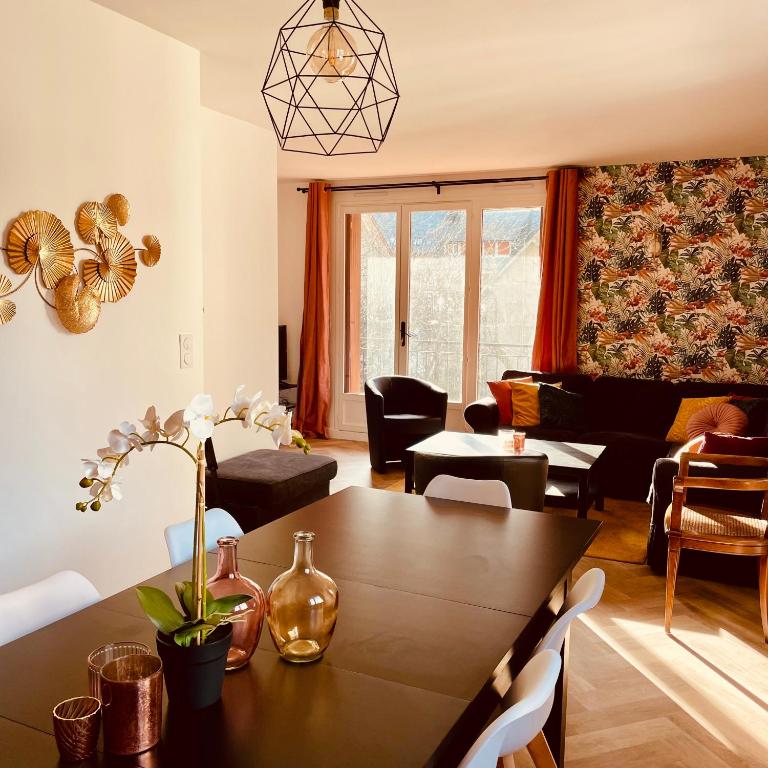 a living room with a table and a couch at L'Ekrin des Cimes in Le Mont-Dore