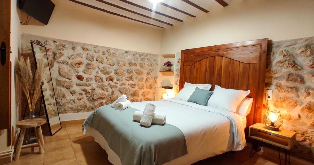 a bedroom with a large bed with a wooden headboard at Las cuevas del agua in Chinchón