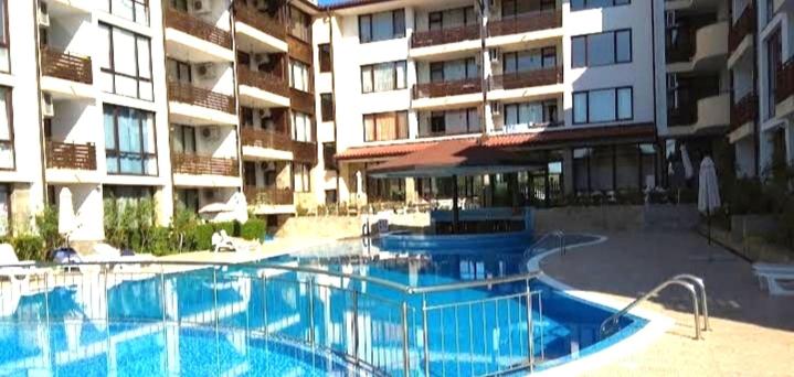 a large swimming pool in front of a building at Victoria's apartments Nesebar in Nesebar