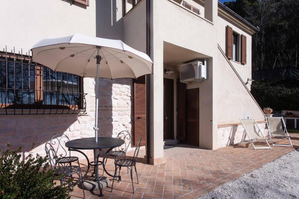 a patio with a table and chairs and an umbrella at A03 - Massignano, bilocale immerso nel verde 1 in Ancona