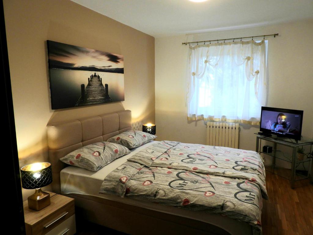 Schlafzimmer mit einem Bett, einem TV und einem Fenster in der Unterkunft Apartment Sol Mar in Portorož