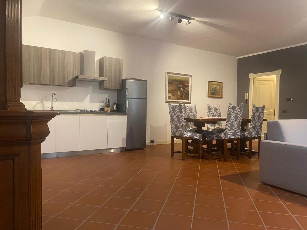 a kitchen with a table and chairs and a refrigerator at Corte Storica in Cortemaggiore