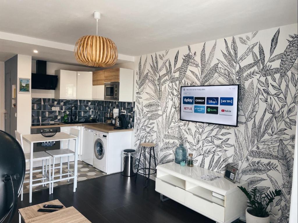 a kitchen and living room with a tv on a wall at NEW: appartement tout confort + parking gratuit in Amiens