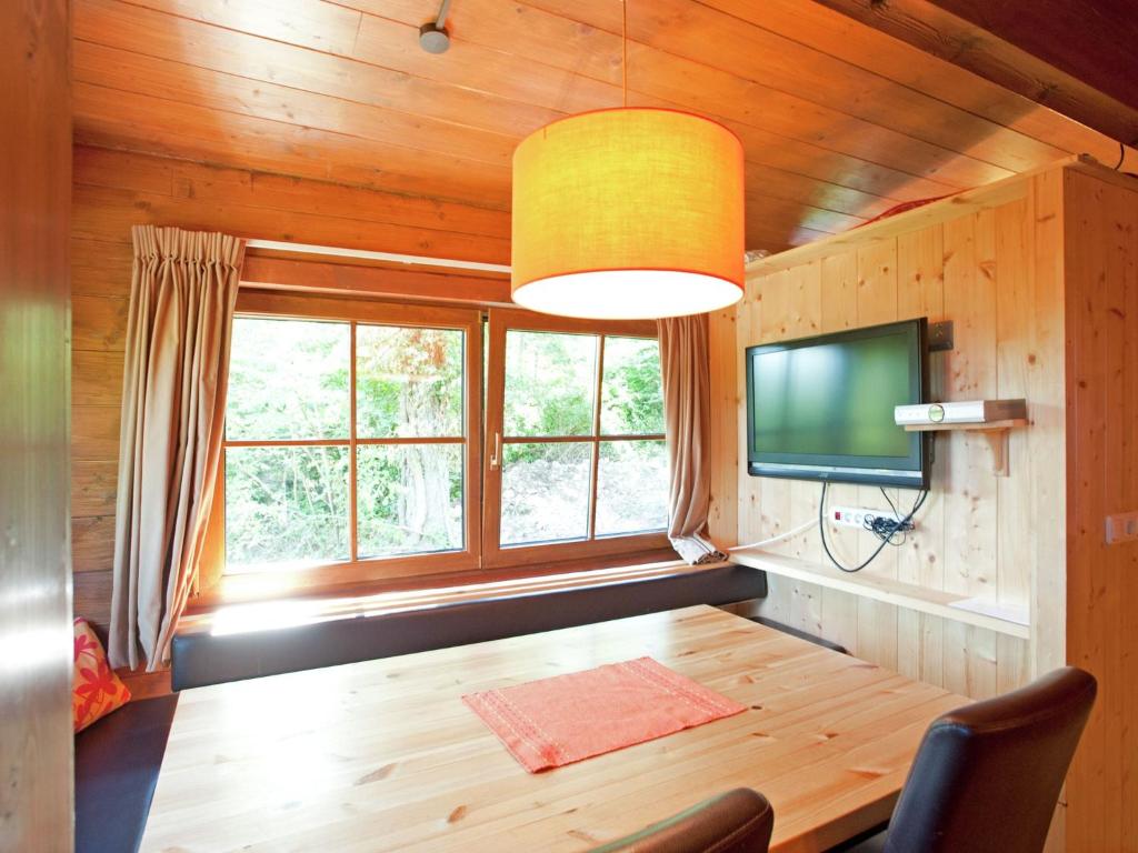 een eetkamer met een houten tafel en een televisie bij Chalet in W rgl near SkiWelt Wilder Kaiser in Salvenberg
