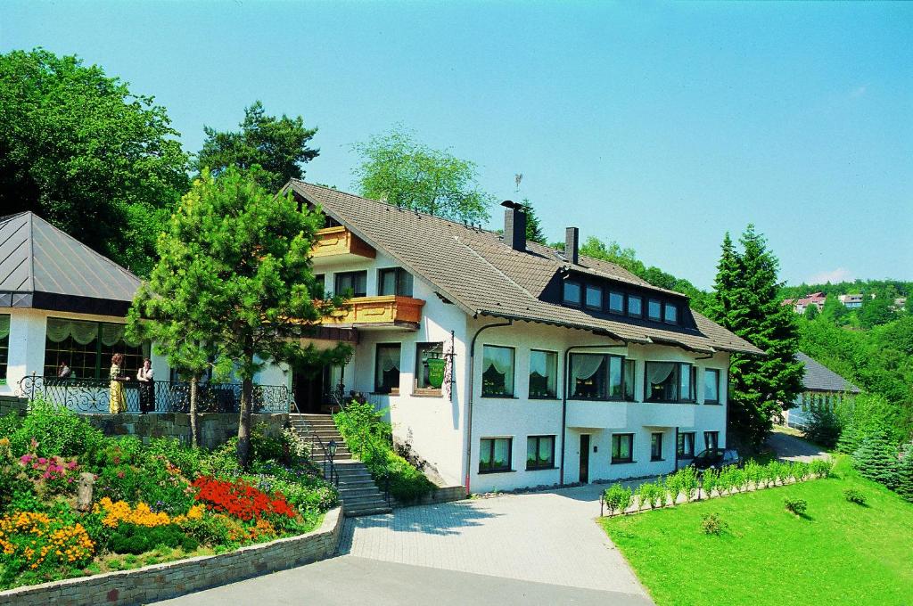 
a white house with a blue roof and a white house at Hotel Auf dem Kamp in Hagen
