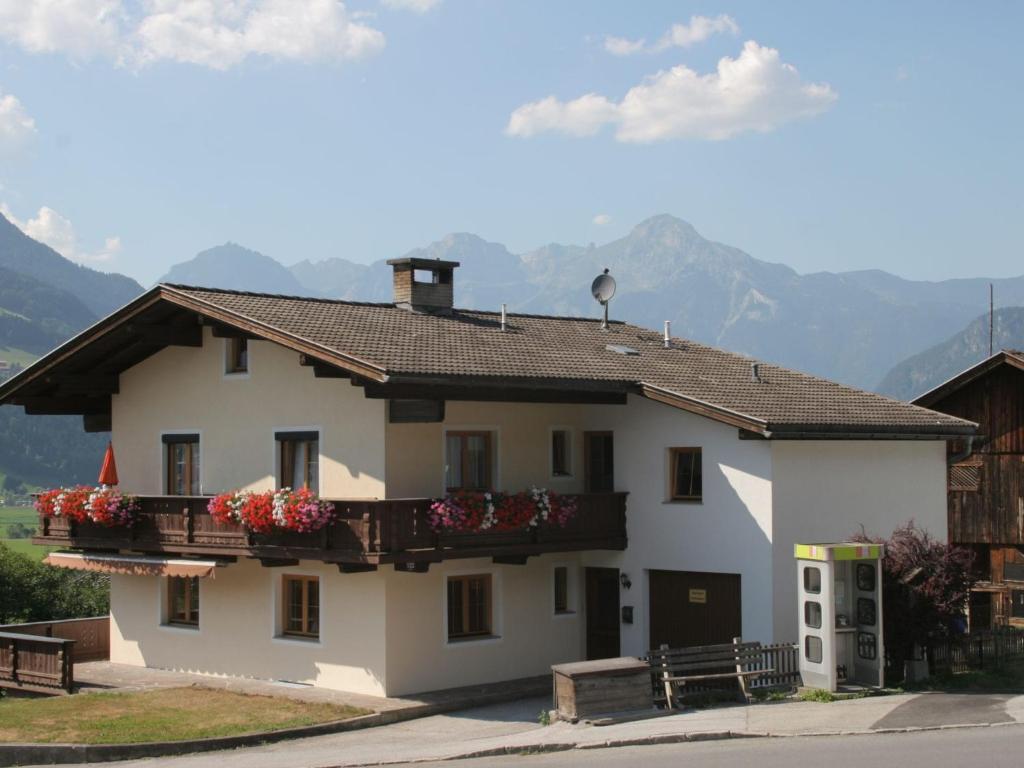 une maison blanche avec des boîtes de fleurs sur elle dans l'établissement Apartment with balcony in Hart im Zillertaler, à Fügen